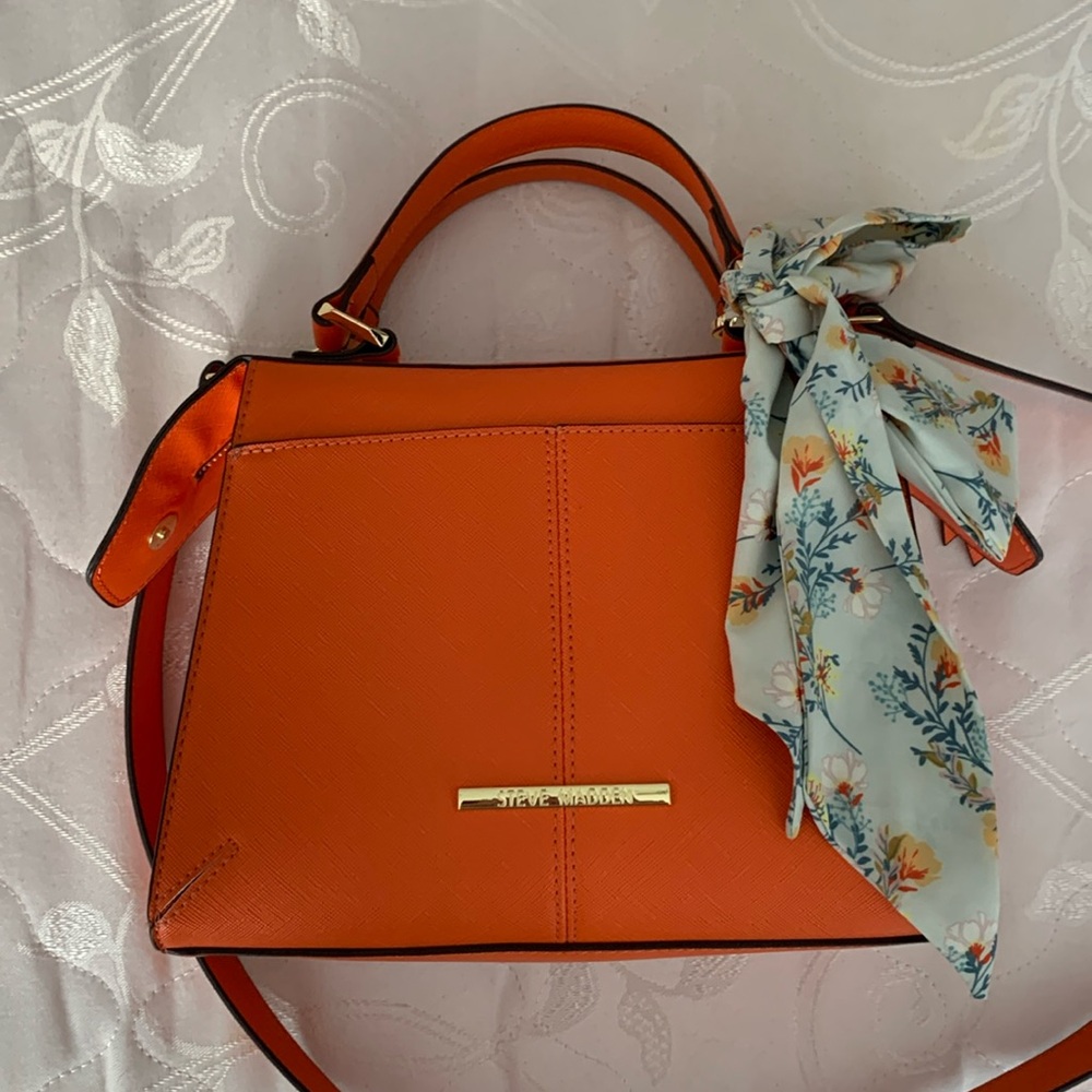 Steve Madden orange purse with gold accents and cream floral scarf